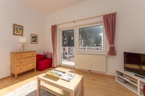 a living room with a red couch and a window at Appartements Maria Stewart by Schladming-Appartements in Schladming