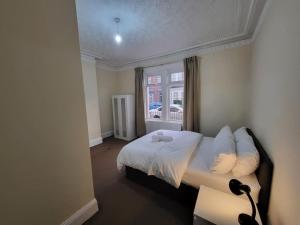 a bedroom with a white bed and a window at 2 Bedroom Flat - both rooms are ensuite in Elswick