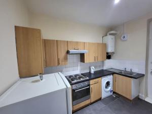 a small kitchen with a stove and a washer at 2 Bedroom Flat - both rooms are ensuite in Elswick