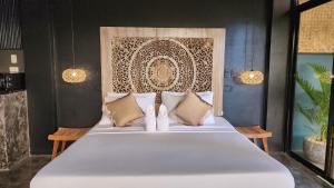 - une chambre avec un grand lit blanc et des oreillers dans l'établissement Unique Stays at Karuna El Nido - The Glasshaus, à El Nido