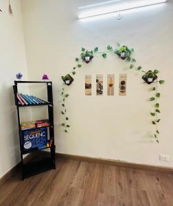 Elite Stays Viman nagar في بيون: غرفة بجدار أبيض عليها نباتات