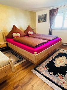 een slaapkamer met een groot bed met roze lakens bij Ferienwohnung Alpensymphonie mit 110 m2 und sonnigem Balkon in Burgberg
