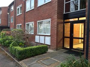 a brick building with a door in front of it at Lady Jane Court by Paymán Club in Trumpington