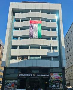 a tall building with a flag on it at Grand Mayfair Hotel in Dubai