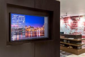 a flat screen tv on a wall in a room at Courtyard Chicago O'Hare in Des Plaines