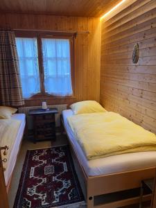 1 dormitorio con 2 camas individuales y ventana en Chalet Kuckuk, en Habkern