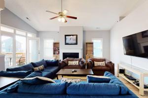 ein Wohnzimmer mit einem blauen Sofa und einem TV in der Unterkunft Blue Heron Nest in Carolina Beach
