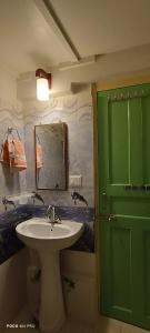a bathroom with a sink and a green door at The Moon Light Home stay in Bhīm Tāl