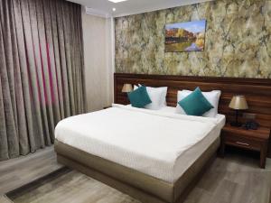 a bedroom with a large bed with green pillows at Korek Mountain Resort in Erbil