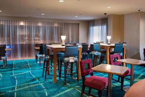 a conference room with tables and chairs andwindows at SpringHill Suites by Marriott Atlanta Alpharetta in Alpharetta