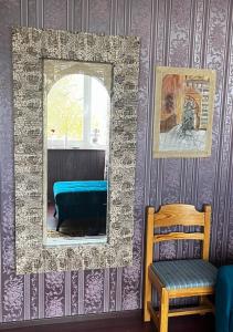 a mirror and a chair in a room with purple wallpaper at Luxurious En-suit room with Sauna in Pyussi