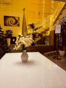 wazon kwiatów siedzący na stole w pokoju w obiekcie Boutique Hotel Manufactura w mieście Tbilisi City