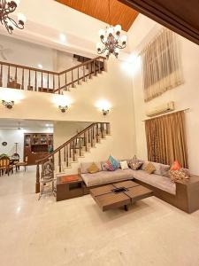 een woonkamer met een bank en een tafel bij WHITEVILLA 5 ROOMS in Pune