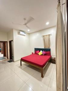 ein Schlafzimmer mit einem roten Bett in einem Zimmer in der Unterkunft WHITEVILLA 5 ROOMS in Pune