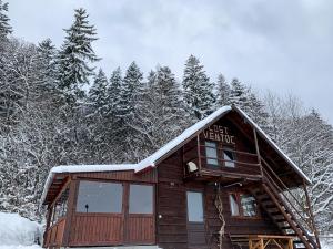 een blokhut in de sneeuw met bomen bij Cabana LoSt Ventoc in Vulcan