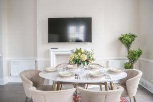 een witte eetkamer met een witte tafel en stoelen bij Spectacular flat located in prime Notting Hill in Londen