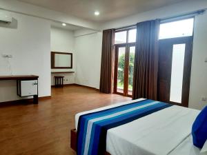 a bedroom with a bed and a large window at Hemalie Resort Mirissa in Mirissa