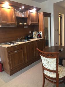 a kitchen with wooden cabinets and a sink and a table at Luxury studio in Bansko