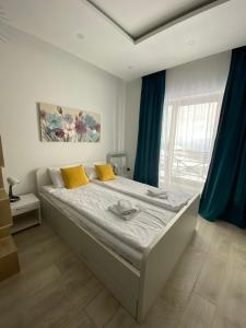 sypialnia z dużym łóżkiem z niebieskimi zasłonami w obiekcie Milmari Resort & Spa P19 w mieście Bukorovac