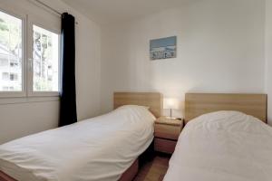 a bedroom with two twin beds and a window at 028- CHU Hôpital, Appart 2chambres, Parking, Tram in Montpellier