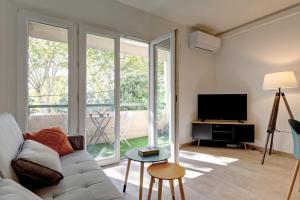 ein Wohnzimmer mit Sofa und Fernseher in der Unterkunft 028- CHU Hôpital, Appart 2chambres, Parking, Tram in Montpellier + 29 Fotos