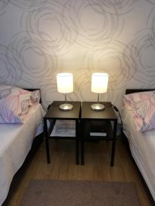 dwa lampy na stołach w pokoju z dwoma łóżkami w obiekcie Eden Panzió w Egerze