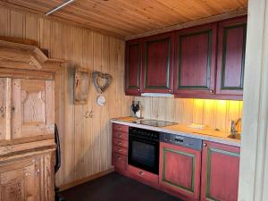 a kitchen with wooden cabinets and a stove at Bjødnabakkvegen 22C in Beitostøl