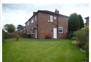 a brick house with a lawn in front of it at The Gold in Manchester