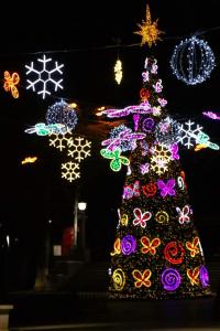 un árbol de Navidad decorado con luces de colores por la noche en Borjomi Home en Borjomi