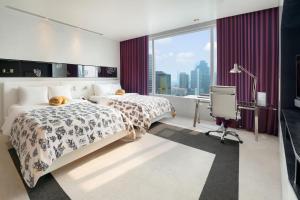 a hotel room with two beds and a window at W Bangkok Hotel in Bangkok