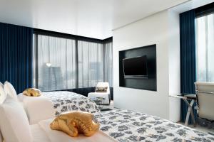 a hotel room with two beds and a flat screen tv at W Bangkok Hotel in Bangkok