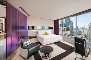 a bedroom with a bed and a desk and chair at W Bangkok Hotel in Bangkok
