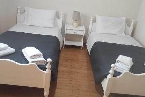 two beds in a room with two white beds at Kostas House in Kouspádes