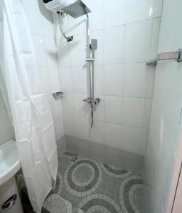 a bathroom with a shower with a tiled floor at Regium Apartment in Lekki