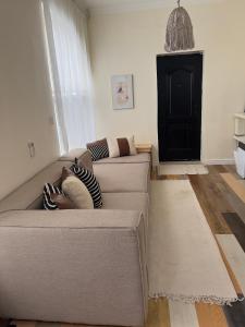 a living room with a gray couch with pillows at Regium Apartment in Lekki