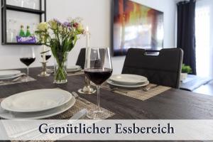 een tafel met een glas rode wijn erop bij Relax-Apartment-One FN in Friedrichshafen