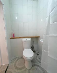 a white bathroom with a toilet and a sink at Regium Apartment in Lekki