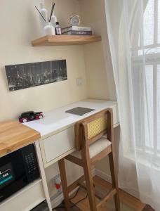 a desk with a chair next to a microwave at Regium Apartment in Lekki