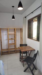 een houten tafel en een stoel in een kamer bij PANTAI POUSADA in Trindade