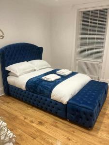 a blue bed with two towels on top of it at Ridley House Apartments in Yarm