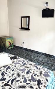 a bedroom with a bed with a pattern on the floor at PANTAI Pousada in Trindade