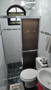 a bathroom with a toilet and a sink at PANTAI Pousada in Trindade +5 photos