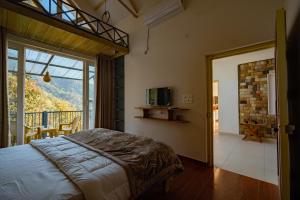 a bedroom with a bed and a balcony at Secluded by The StayCationer in Kandogal