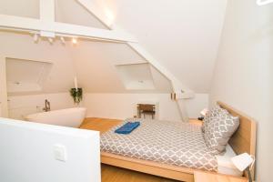 an attic bedroom with a bed and a bathroom at Dream duplex near the Royal Palace - city center in Brussels