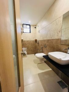 a bathroom with a sink and a toilet at Hotel Venus By Mantram Hospitality in Rajkot