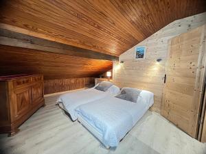 um quarto com 2 camas e um tecto de madeira em Ty Menez 2 - Chalet sur les pistes em La Clusaz