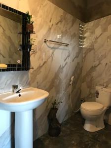 uma casa de banho com um lavatório e um WC em Sky home stay em Kandy