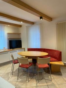 a room with a table and chairs and a couch at Appartamento Rio Duron in Campitello di Fassa