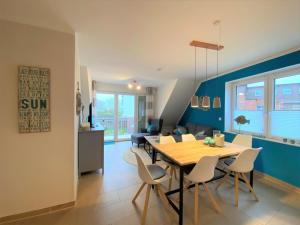 a dining room and living room with a table and chairs at Hafenperle 21 - Traum am Hafen in Norddeich