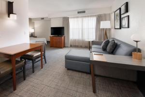 a living room with a couch and a table in a hotel room at Residence Inn by Marriott Rogers in Rogers